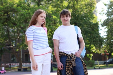 Photo of Teenage girl and boy walking together outdoors