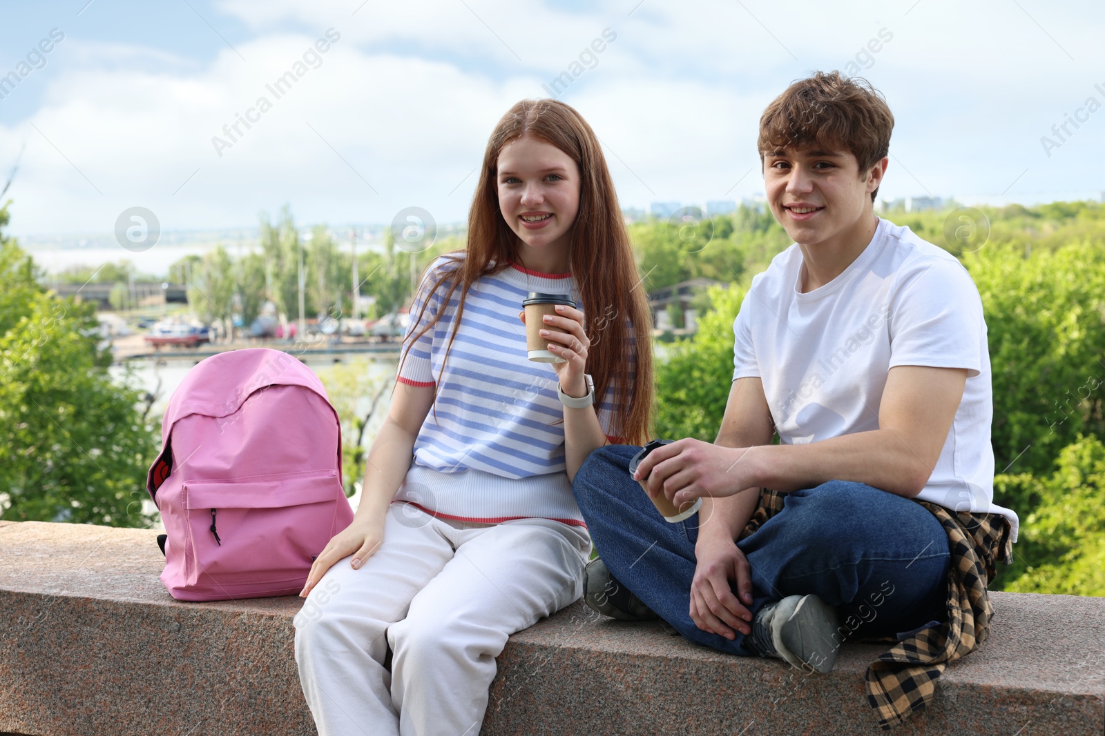 Teenage girl and boy with drinks outdoors Photo of Teenage girl and boy with drinks outdoors