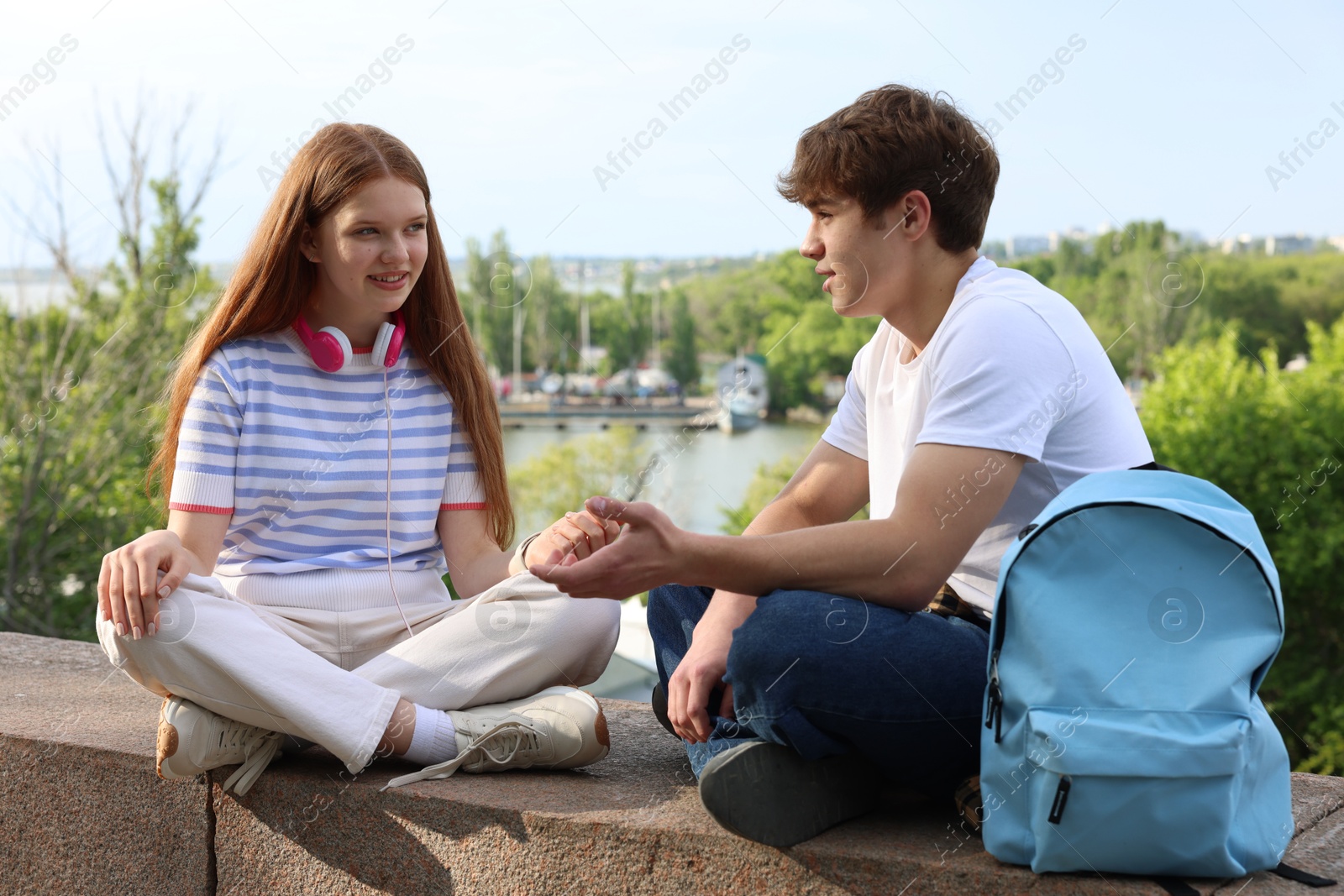 Teenage girl and boy spending time together outdoors Photo of Teenage girl and boy spending time together outdoors