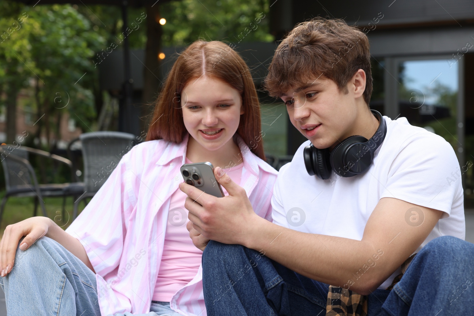 Teenage girl and boy with smartphone outdoors Photo of Teenage girl and boy with smartphone outdoors