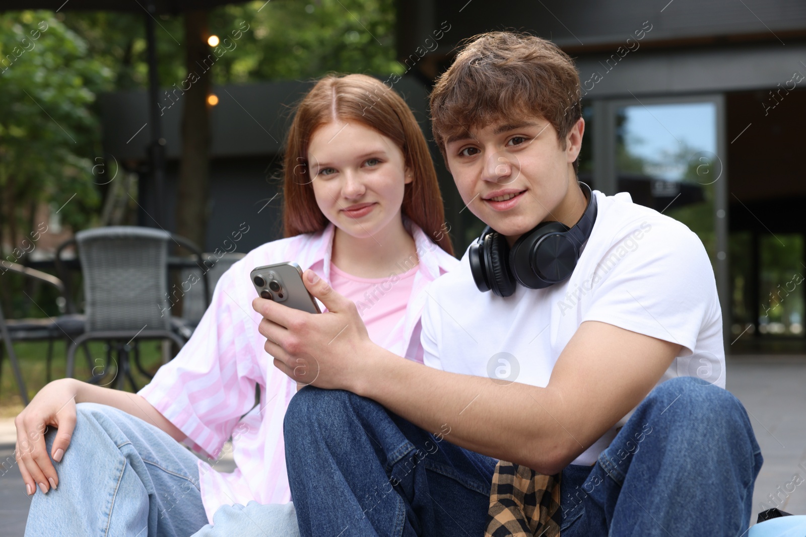 Teenage girl and boy with smartphone outdoors Photo of Teenage girl and boy with smartphone outdoors