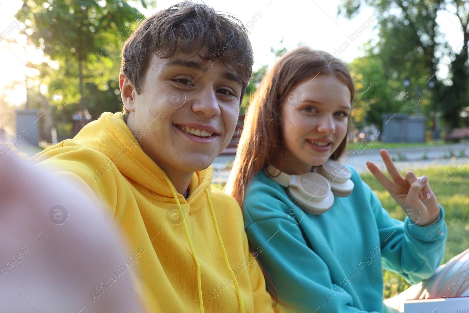 Teenage girl and boy taking selfie together in park Photo of Teenage girl and boy taking selfie together in park