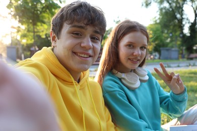 Photo of Teenage girl and boy taking selfie together in park