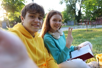 Photo of Teenage girl and boy taking selfie together in park