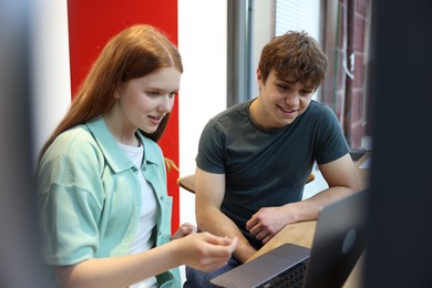 Photo of Teenage girl and boy with laptop indoors
