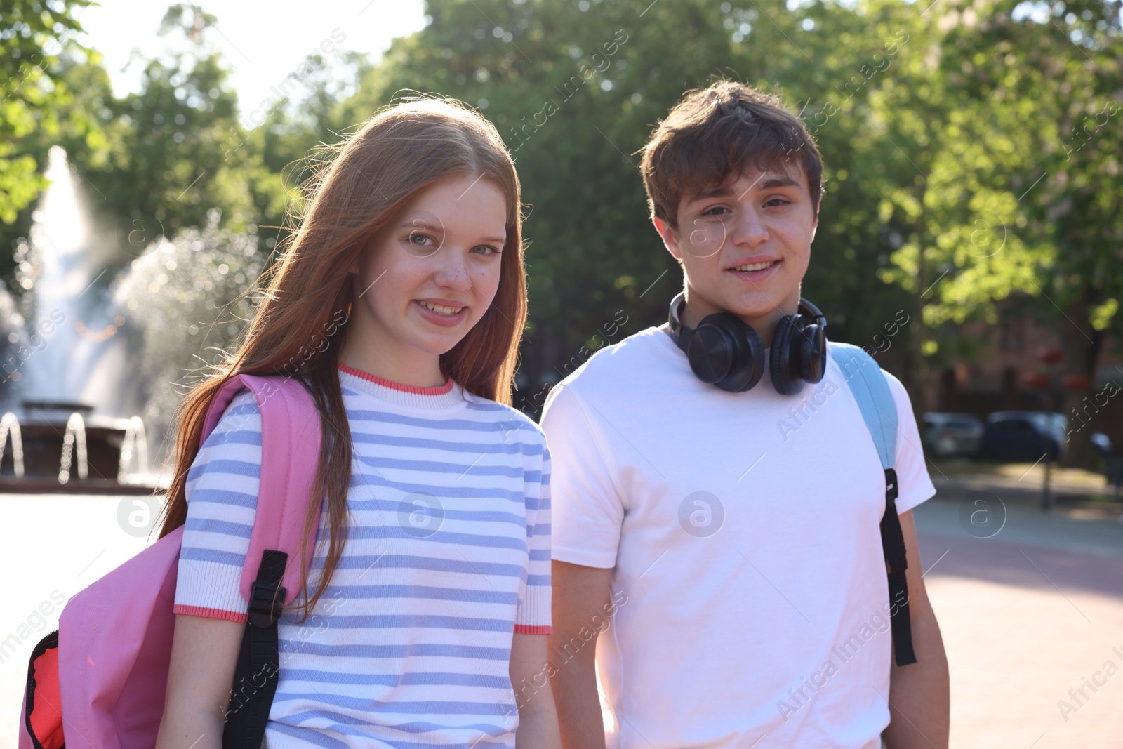 Teenage girl and boy walking together in park Photo of Teenage girl and boy walking together in park