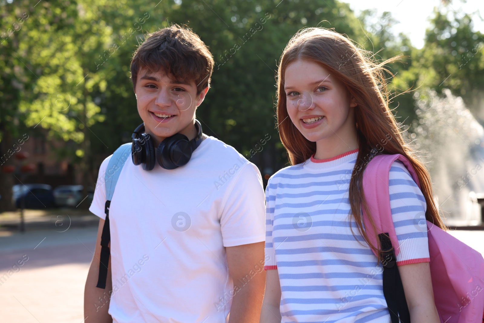 Teenage girl and boy walking together in park Photo of Teenage girl and boy walking together in park