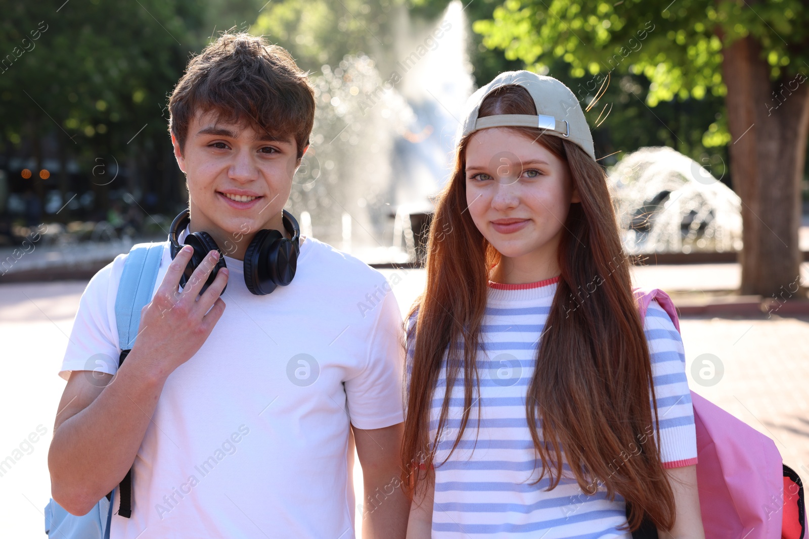 Teenage girl and boy walking together in park Photo of Teenage girl and boy walking together in park
