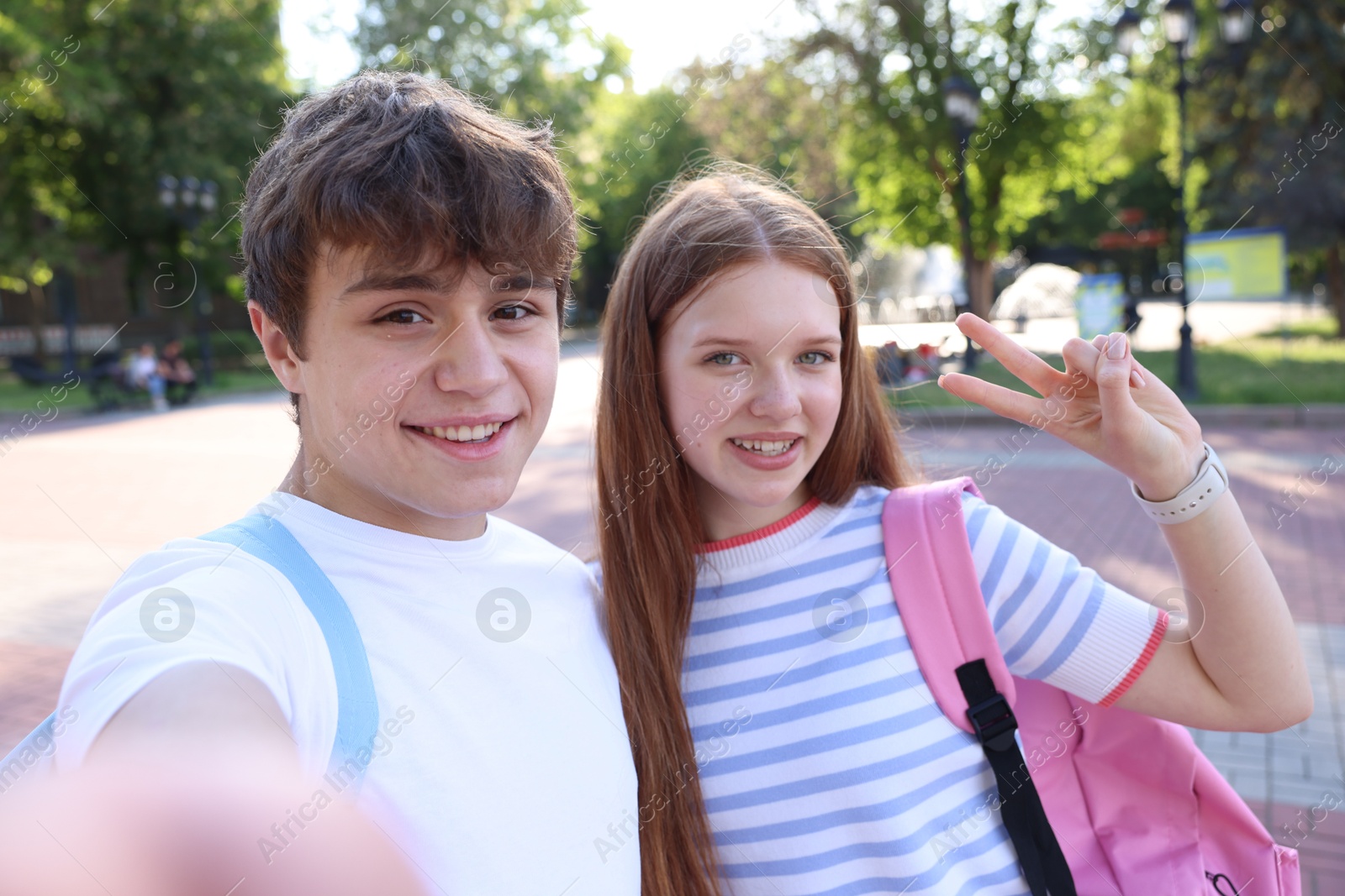 Teenage girl and boy taking selfie together in park Photo of Teenage girl and boy taking selfie together in park