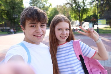 Photo of Teenage girl and boy taking selfie together in park