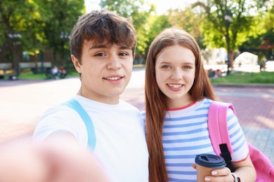 Photo of Teenage girl and boy taking selfie together in park