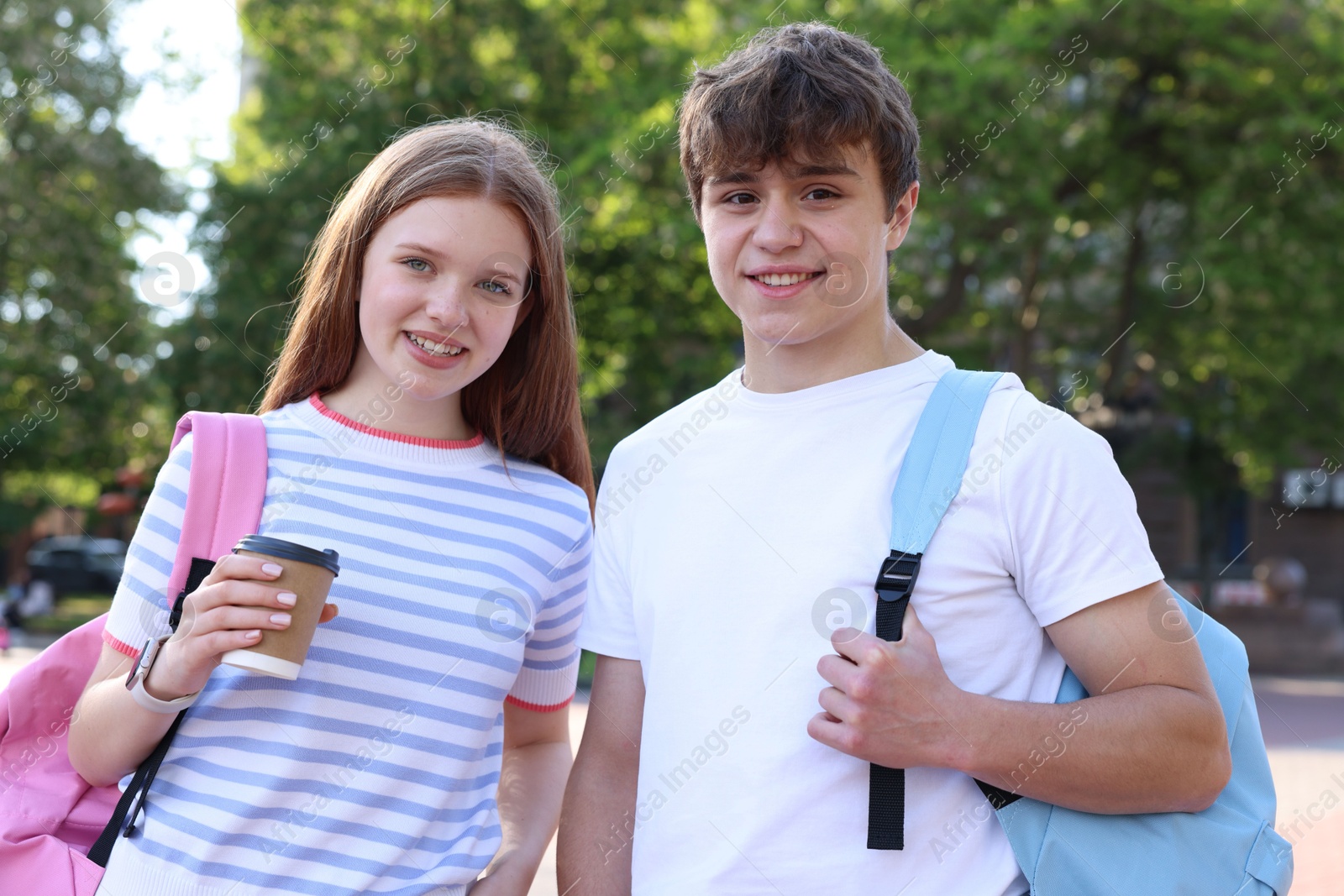 Teenage boy and girl with drink outdoors Photo of Teenage boy and girl with drink outdoors