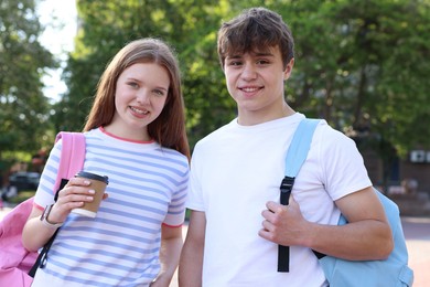 Photo of Teenage boy and girl with drink outdoors
