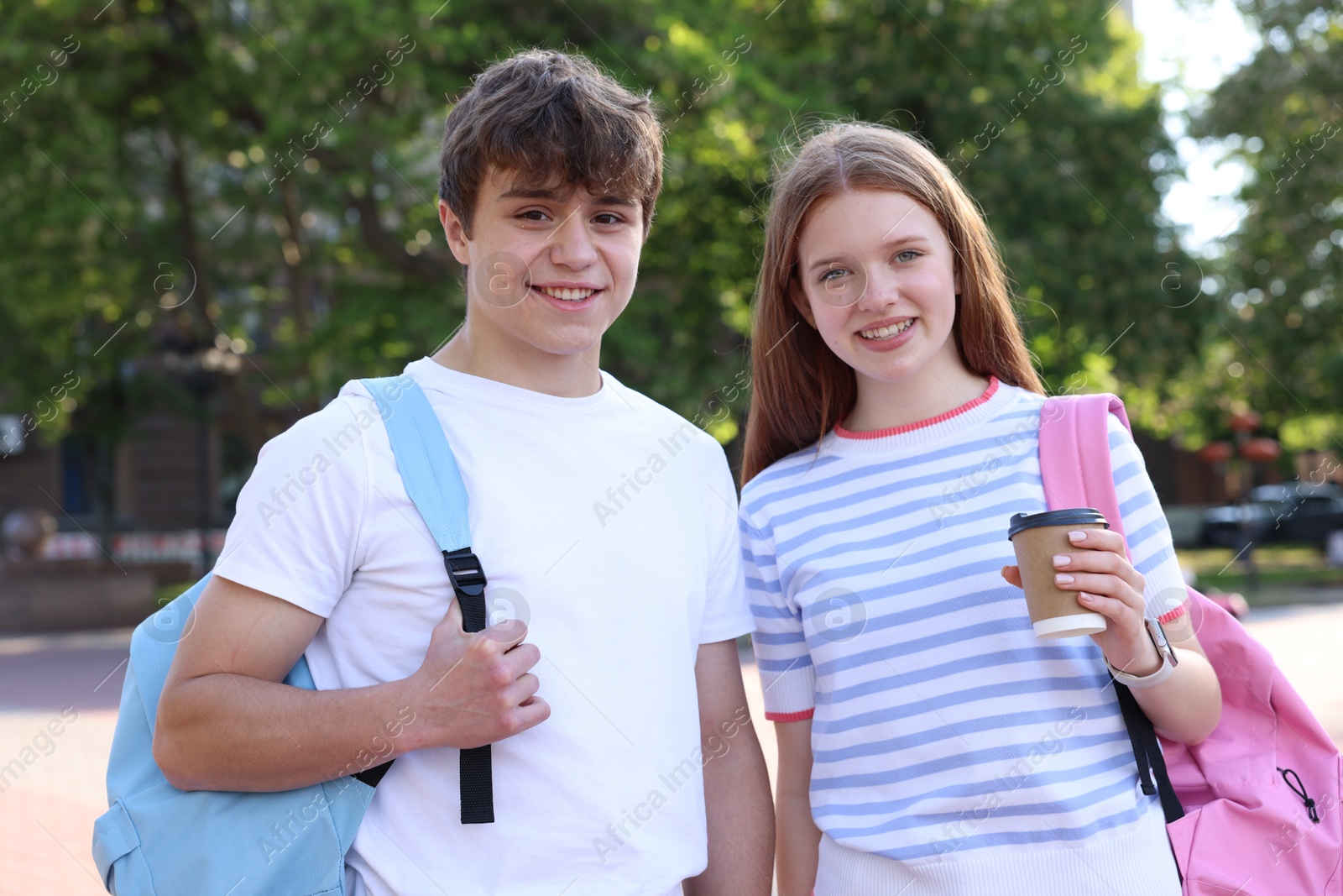 Teenage boy and girl with drink outdoors Photo of Teenage boy and girl with drink outdoors