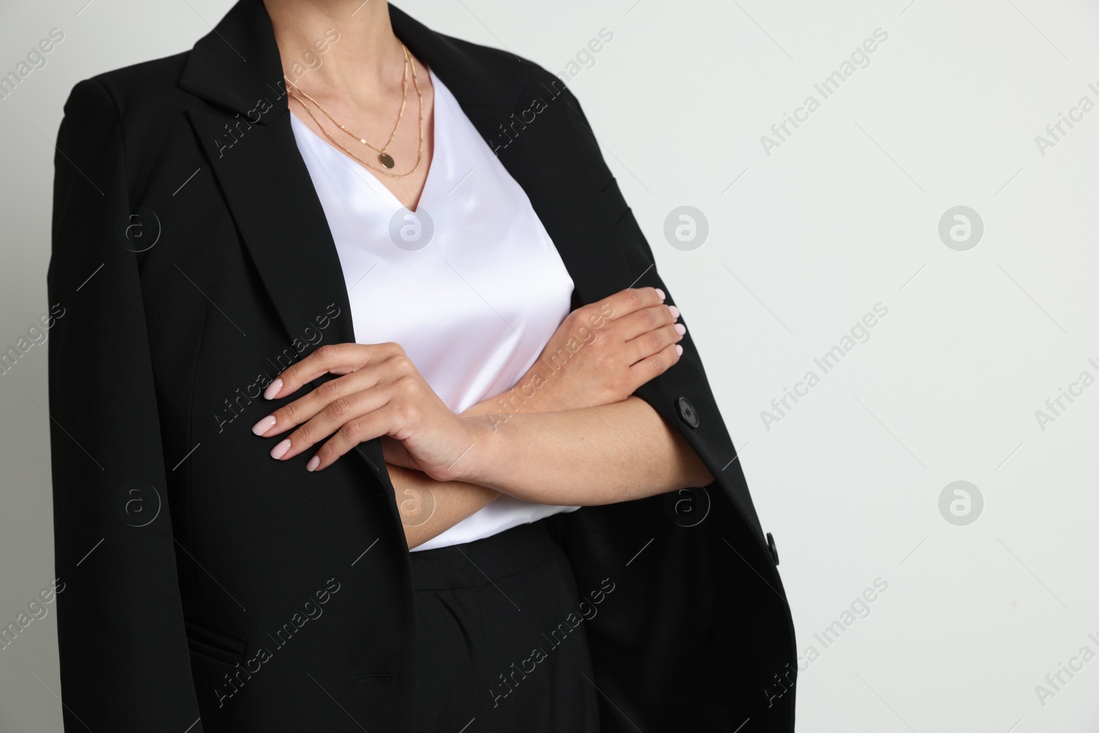 Confident business woman in suit on light background, closeup Photo of Confident business woman in suit on light background, closeup