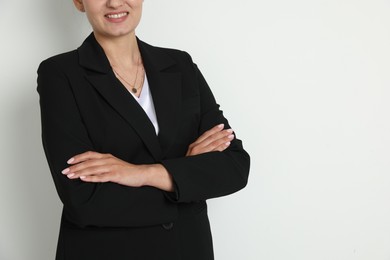 Photo of Confident business woman in suit on light background, closeup. Space for text