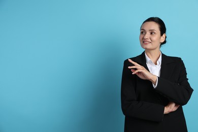 Photo of Confident business woman in suit on light blue background. Space for text