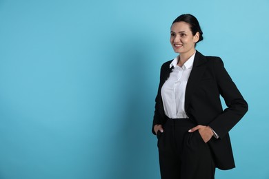 Photo of Confident business woman in suit on light blue background. Space for text