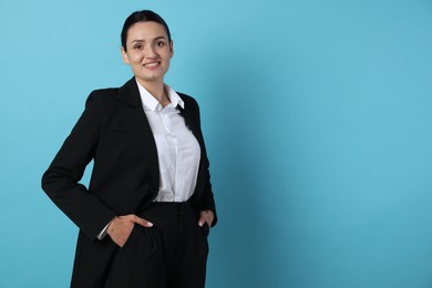 Photo of Confident business woman in suit on light blue background. Space for text