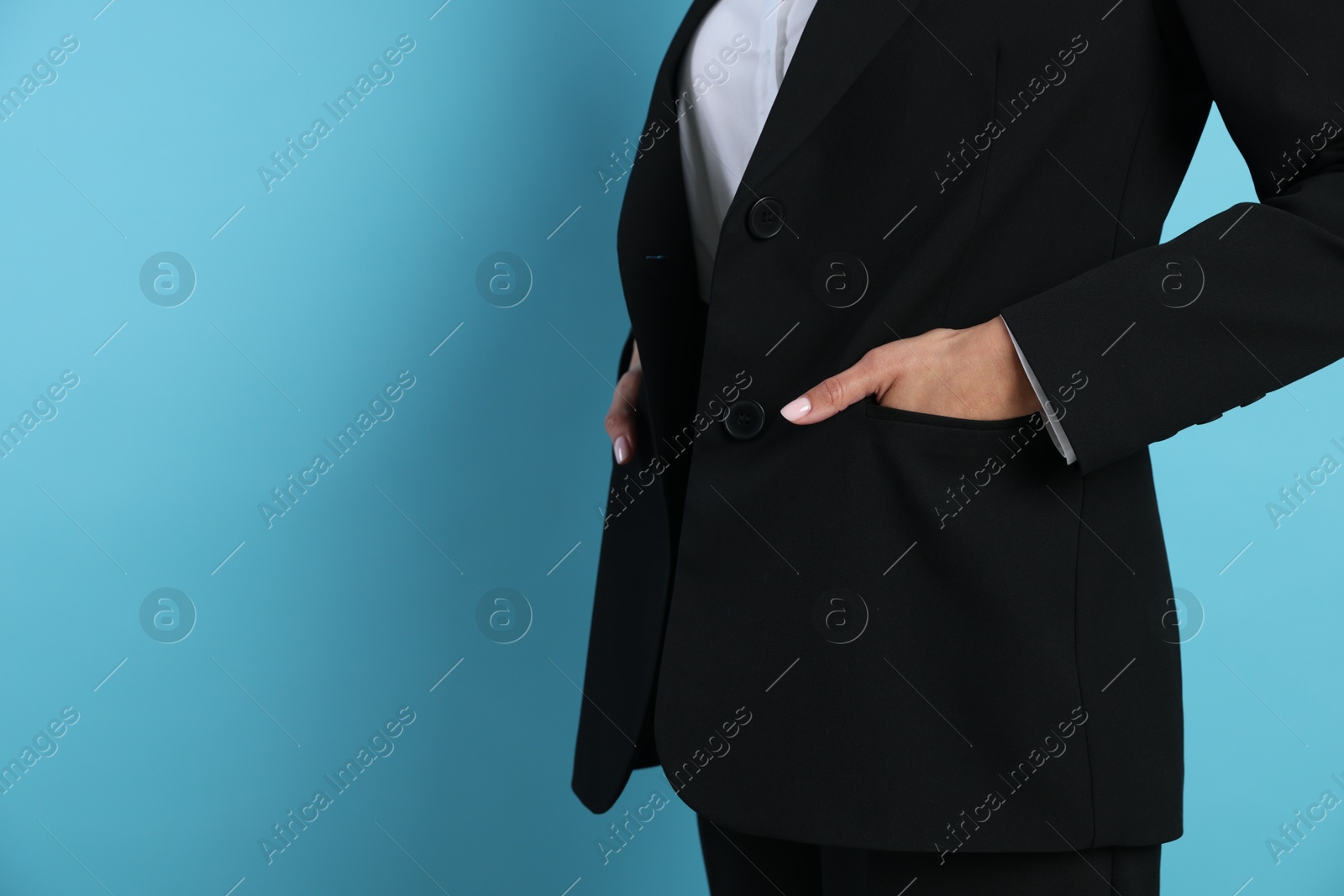 Confident business woman in suit on light blue background, closeup. Space for text Photo of Confident business woman in suit on light blue background, closeup. Space for text