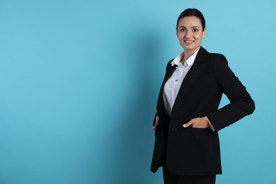 Photo of Confident business woman in suit on light blue background. Space for text