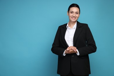 Photo of Confident business woman in suit on light blue background. Space for text