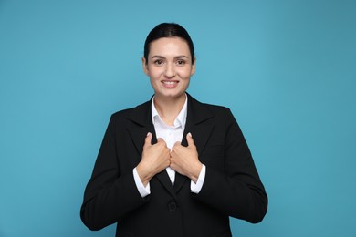 Photo of Confident business woman in suit on light blue background