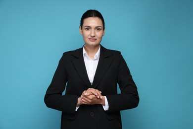 Photo of Confident business woman in suit on light blue background