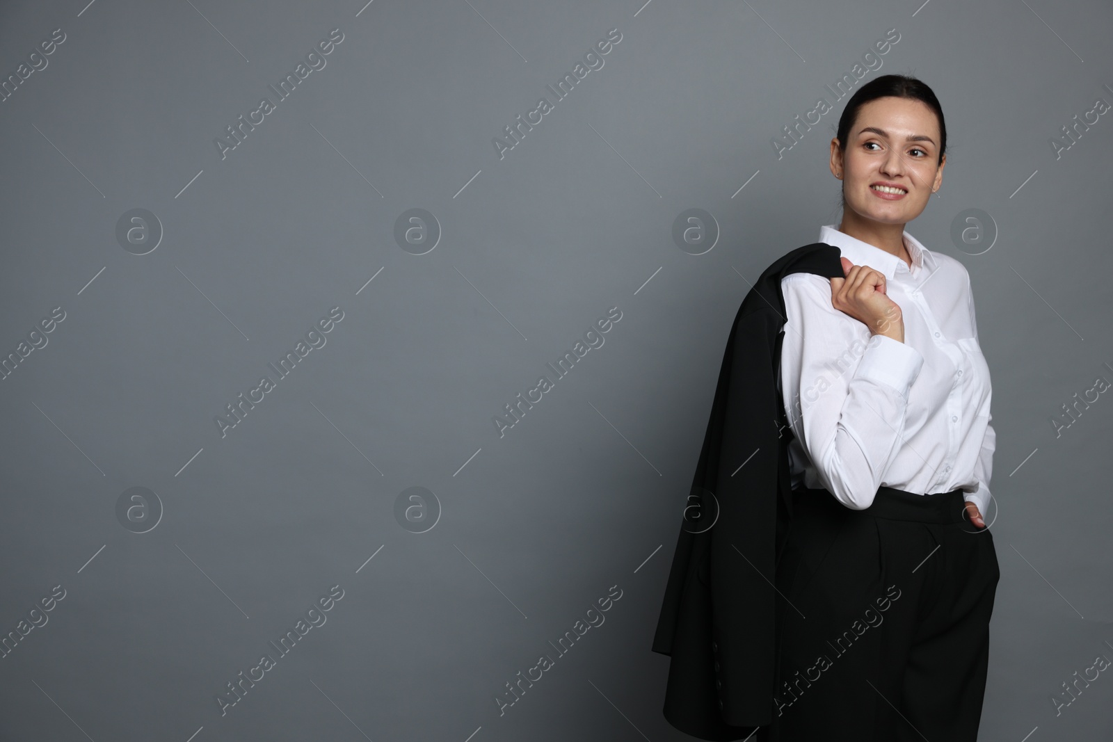 Confident business woman in suit on grey background. Space for text Photo of Confident business woman in suit on grey background. Space for text