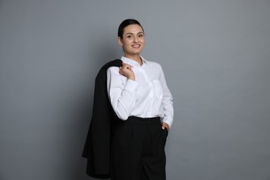 Photo of Confident business woman in suit on grey background