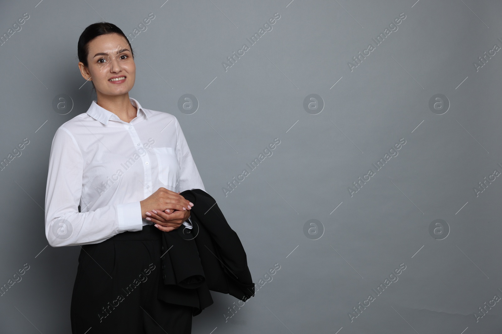 Confident business woman in suit on grey background. Space for text Photo of Confident business woman in suit on grey background. Space for text