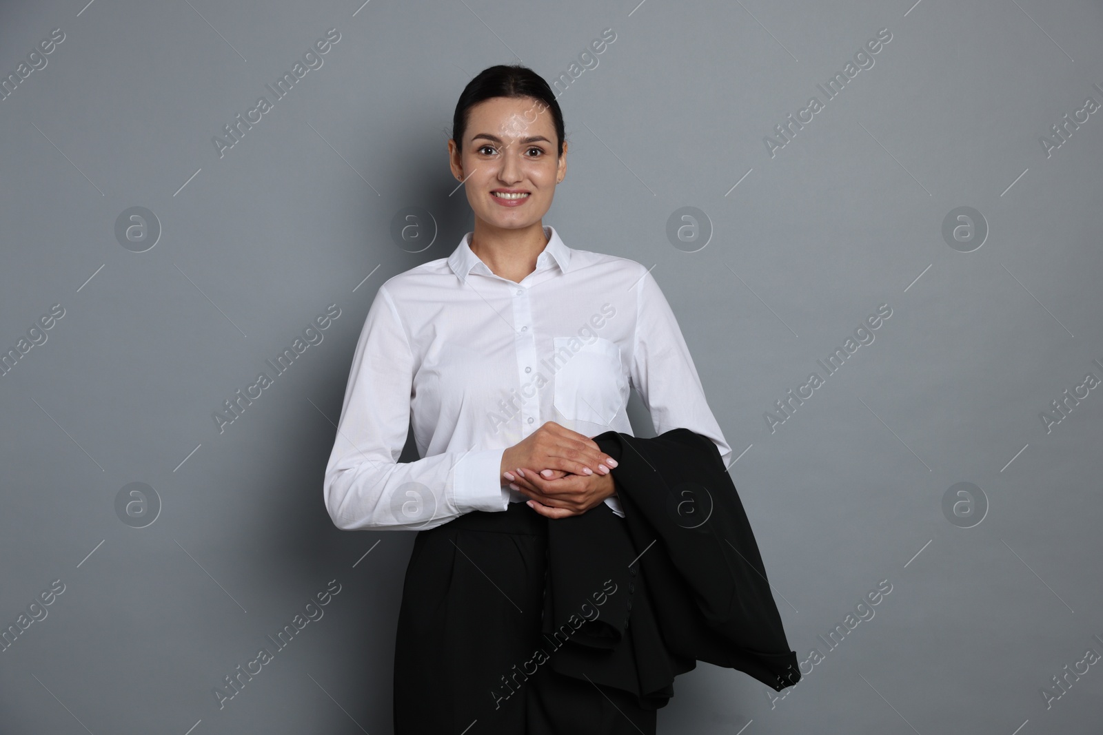 Confident business woman in suit on grey background Photo of Confident business woman in suit on grey background