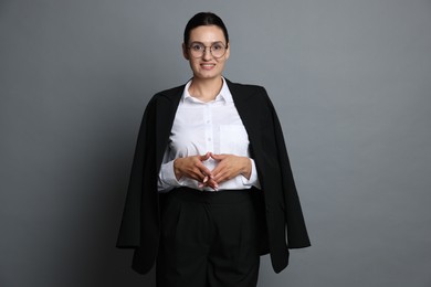 Photo of Confident business woman in suit on grey background