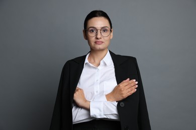 Photo of Confident business woman in suit on grey background
