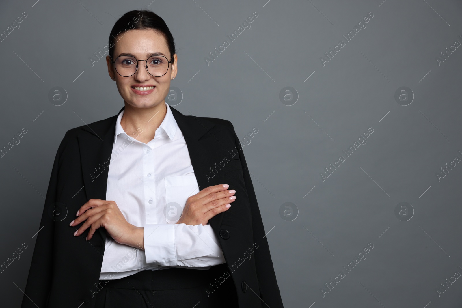 Confident business woman in suit on grey background. Space for text Photo of Confident business woman in suit on grey background. Space for text