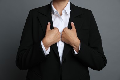 Photo of Confident business woman in suit on grey background, closeup