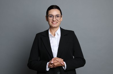 Photo of Confident business woman in suit on grey background