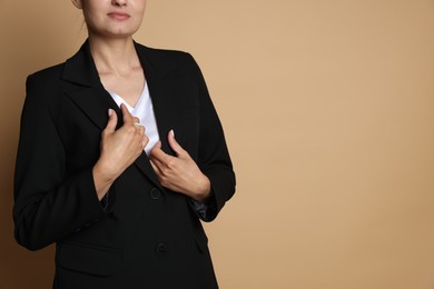 Photo of Confident business woman in suit on beige background, closeup. Space for text