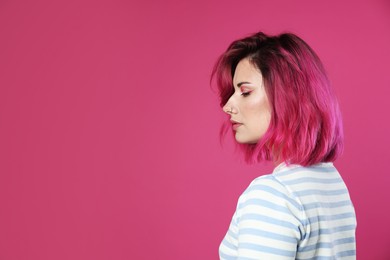 Photo of Beautiful woman with bright dyed hair on pink background, space for text