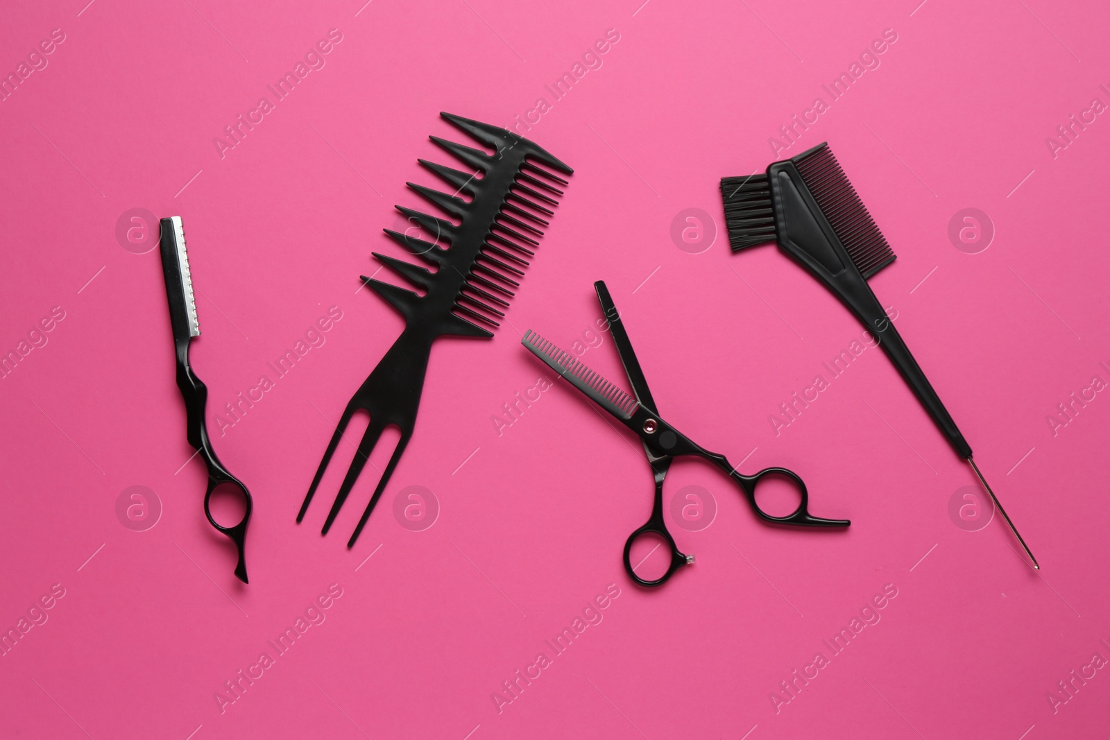 Photo of Different hairdresser's tools on pink background, flat lay