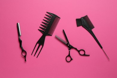 Photo of Different hairdresser's tools on pink background, flat lay
