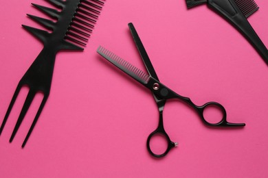 Photo of Different hairdresser's tools on pink background, flat lay