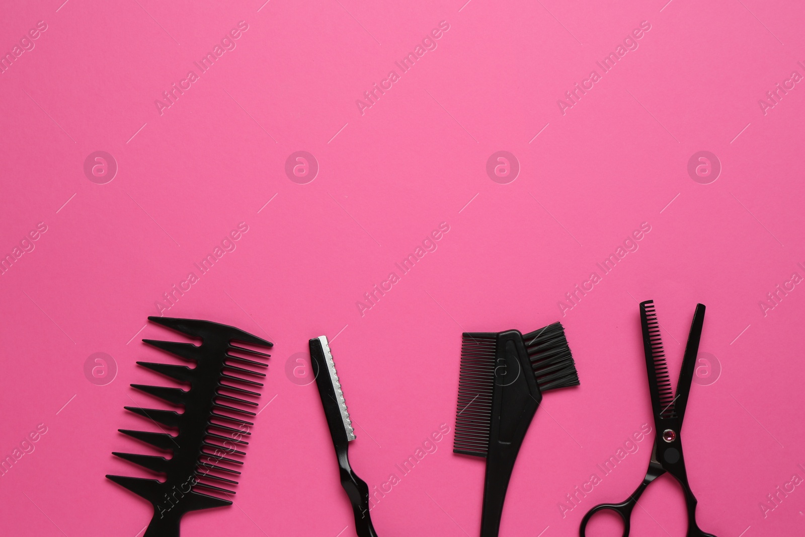 Photo of Different hairdresser's tools on pink background, flat lay. Space for text