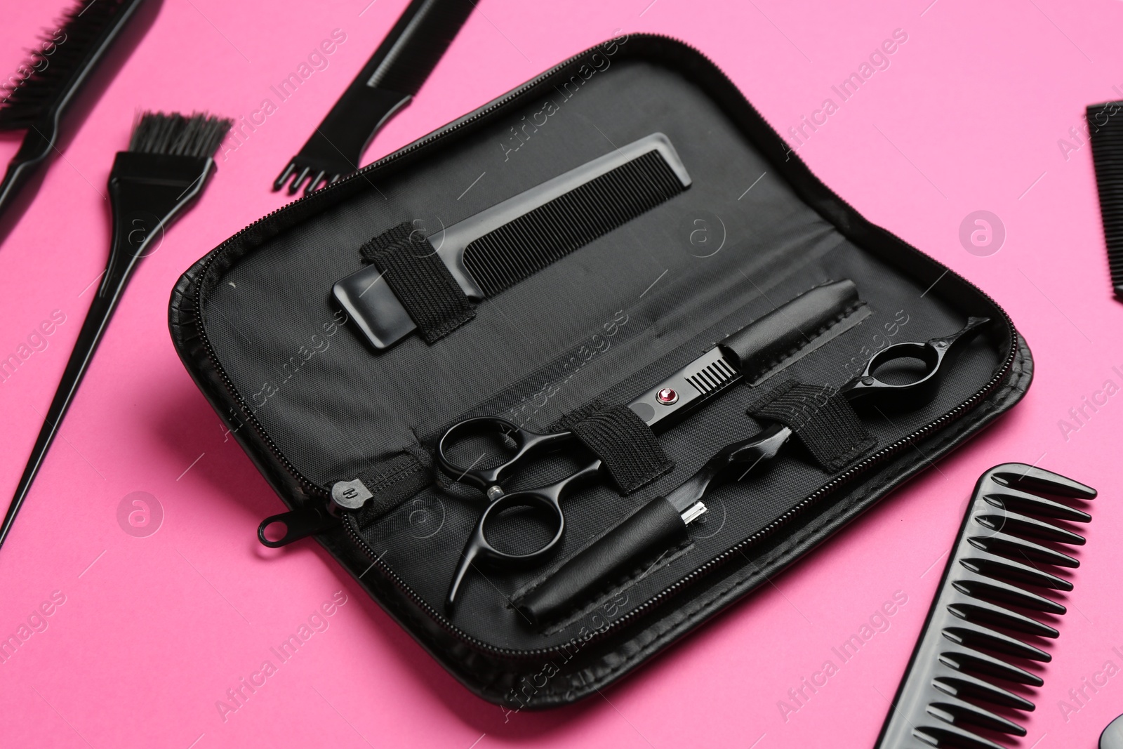 Photo of Different hairdresser's tools on pink background, above view