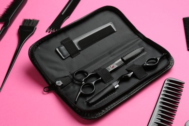 Photo of Different hairdresser's tools on pink background, above view