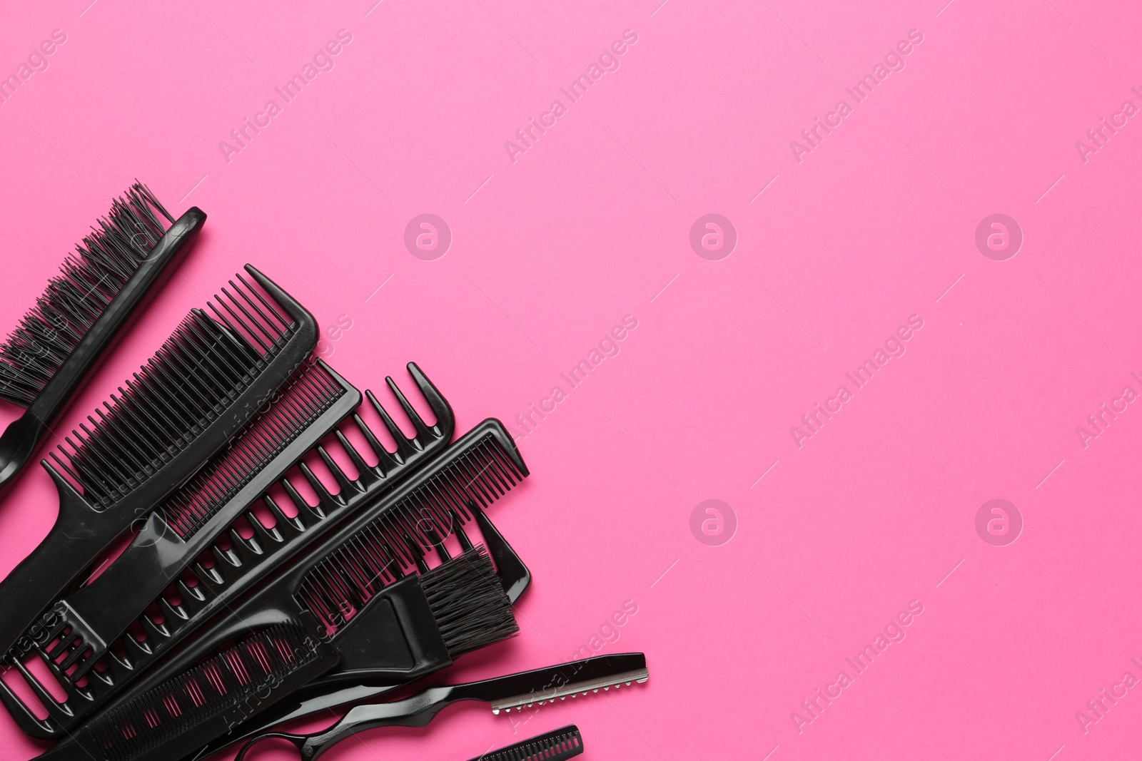 Photo of Different hairdresser's tools on pink background, flat lay. Space for text