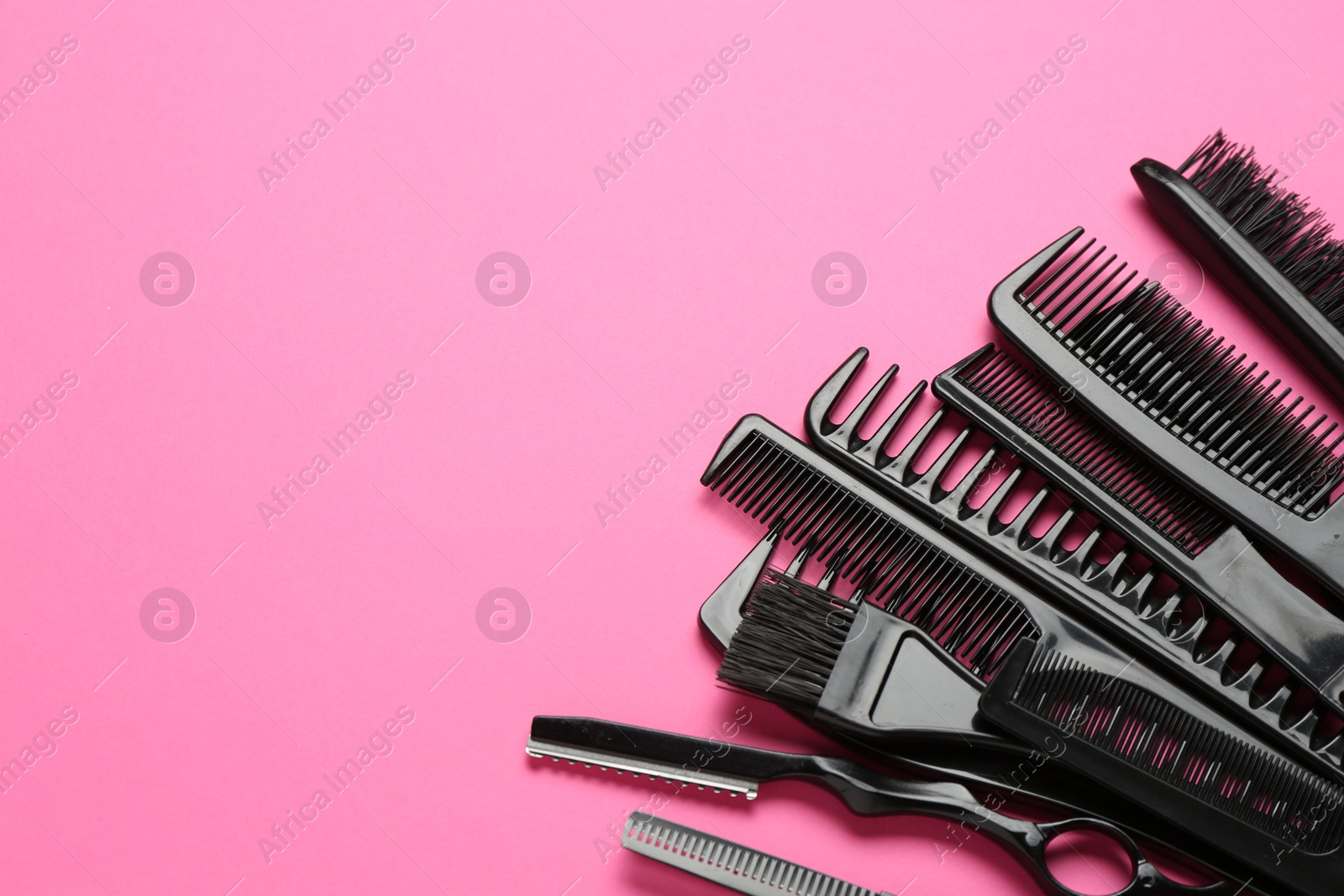 Photo of Different hairdresser's tools on pink background, above view. Space for text