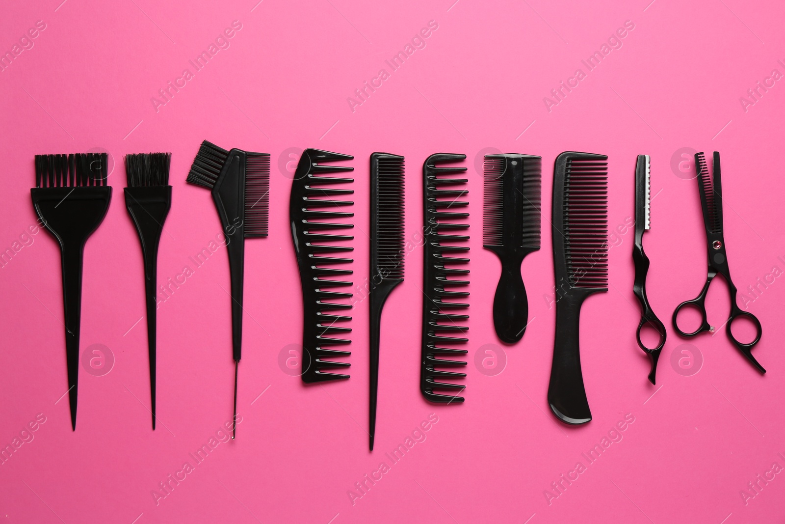 Photo of Different hairdresser's tools on pink background, flat lay