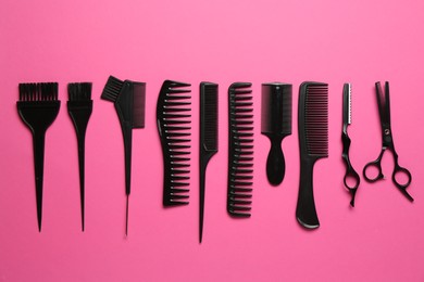 Photo of Different hairdresser's tools on pink background, flat lay