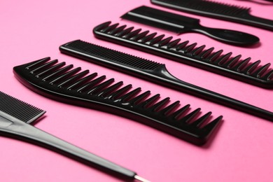 Photo of Different hairdresser's tools on pink background, closeup